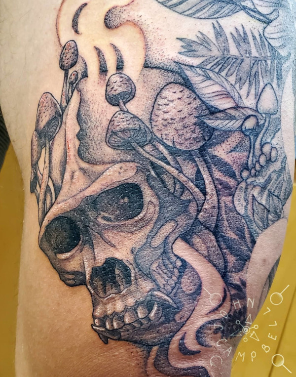 Skull with mushrooms and smoke black and grey thigh tattoo by John Campbell at Sacred Mandala Studio tattoo parlor in Durham, NC.